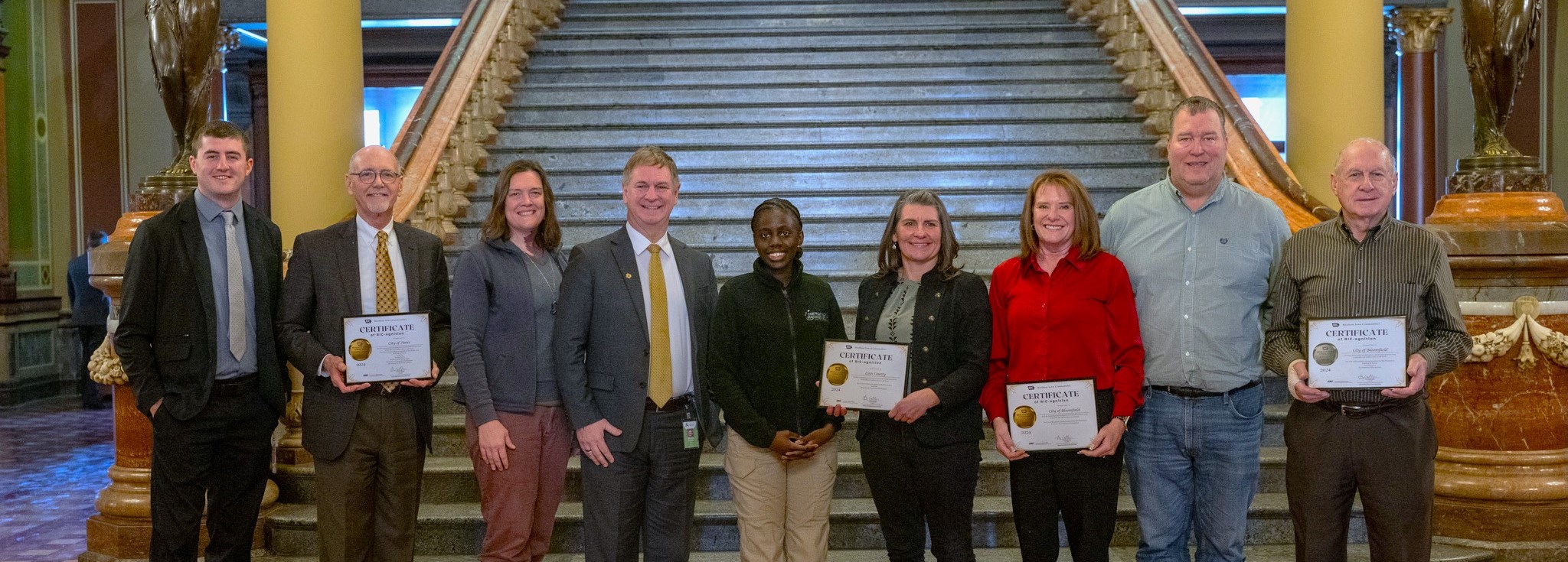 recognition award recipients posing with their awards at the capitol building in des moines