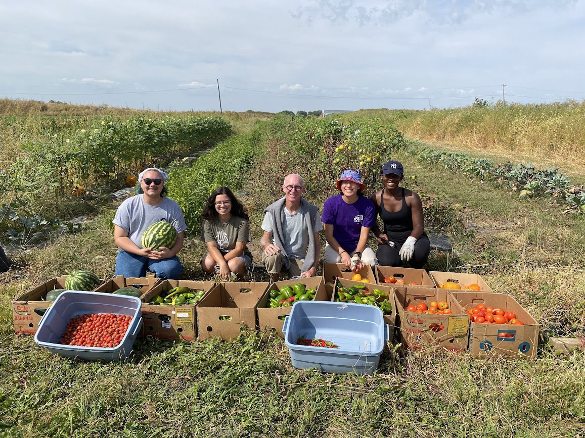 VISTA members serving with Table to Table posing with vegetables they harvested