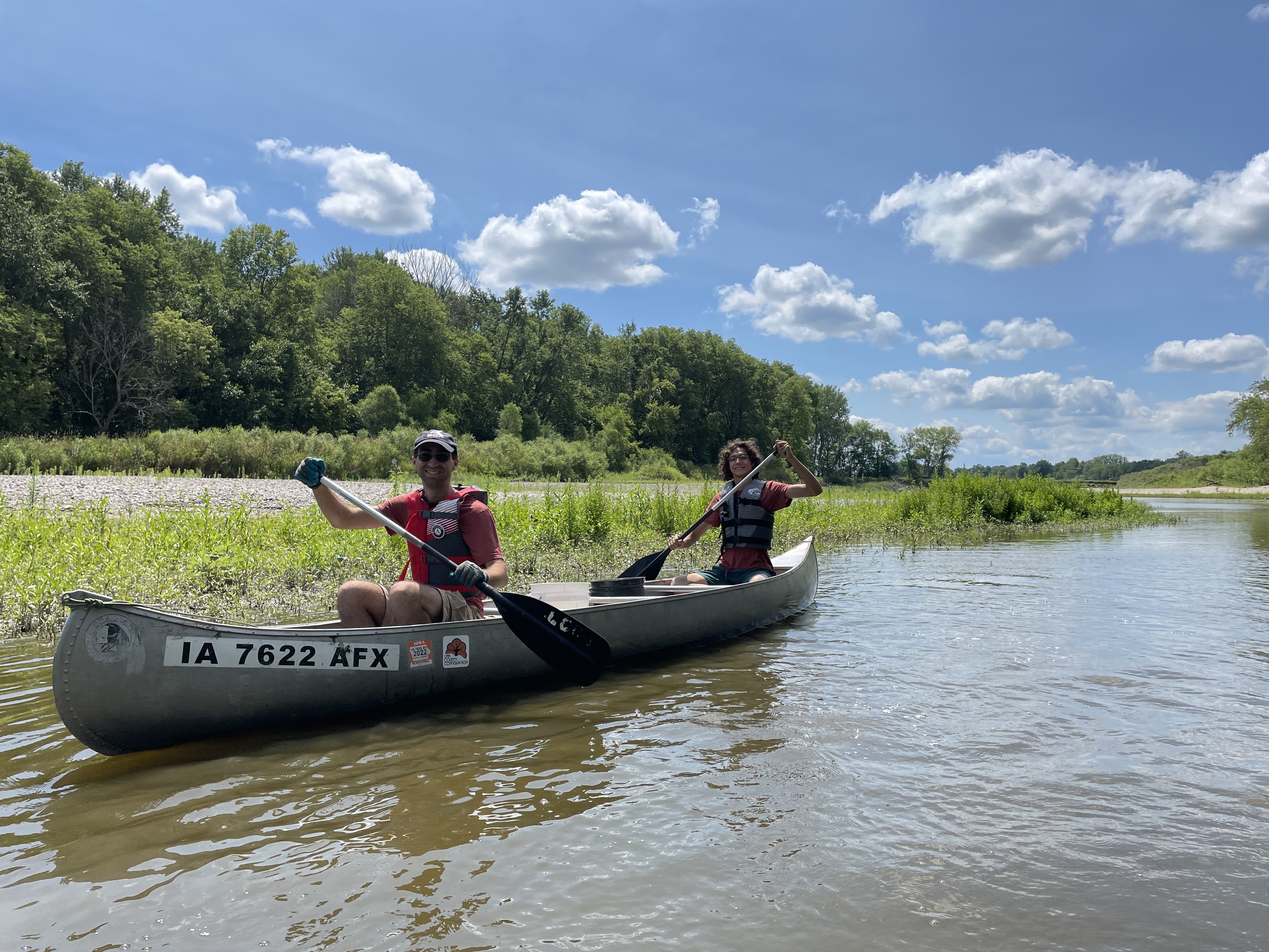 Two AmeriCorps members canoeing down a river